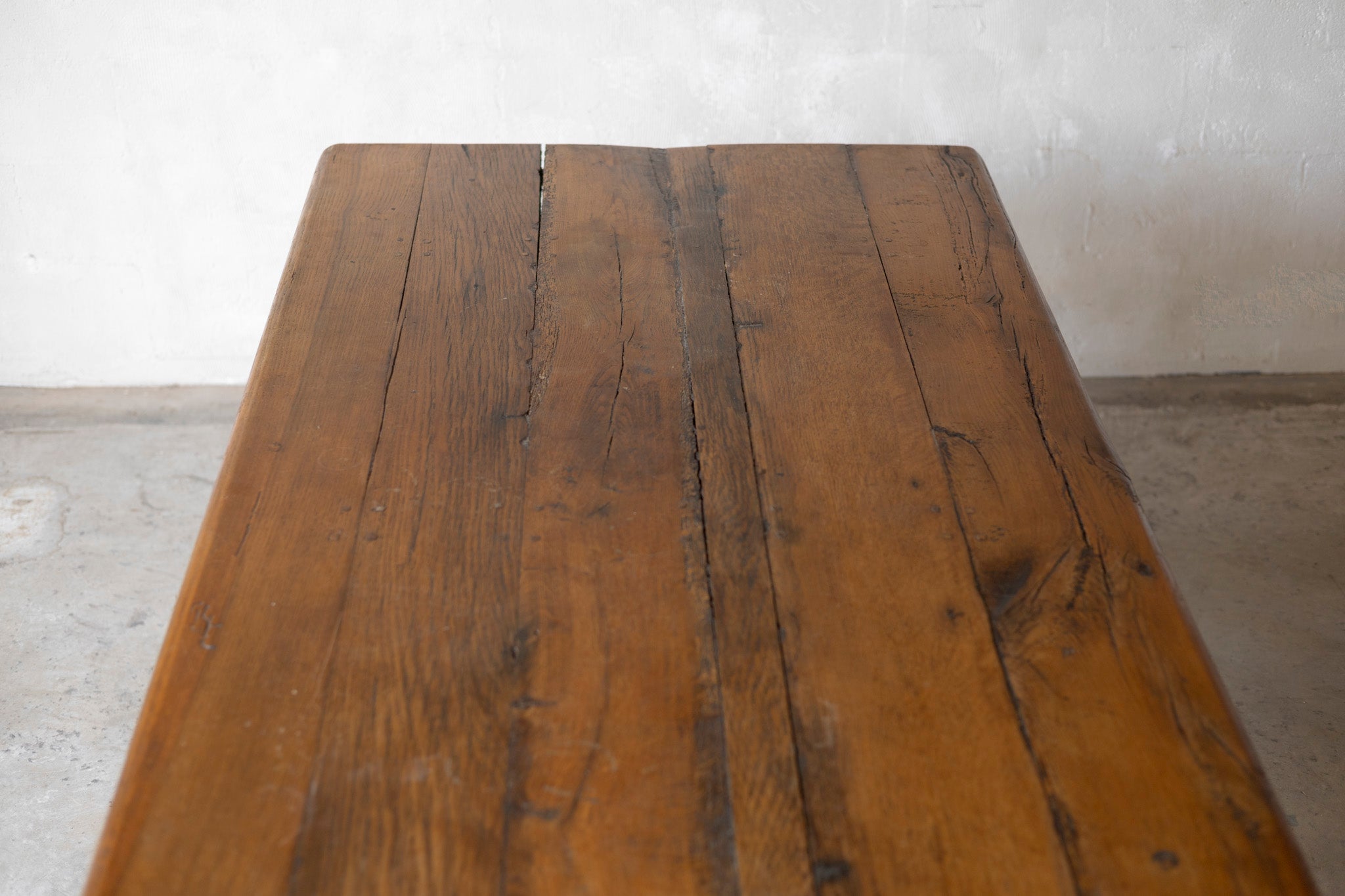 Wooden table with a rustic appearance against a plain wall.