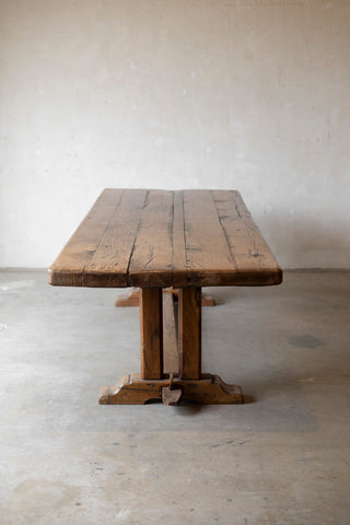 Wooden table with a rustic design on a plain floor and wall background