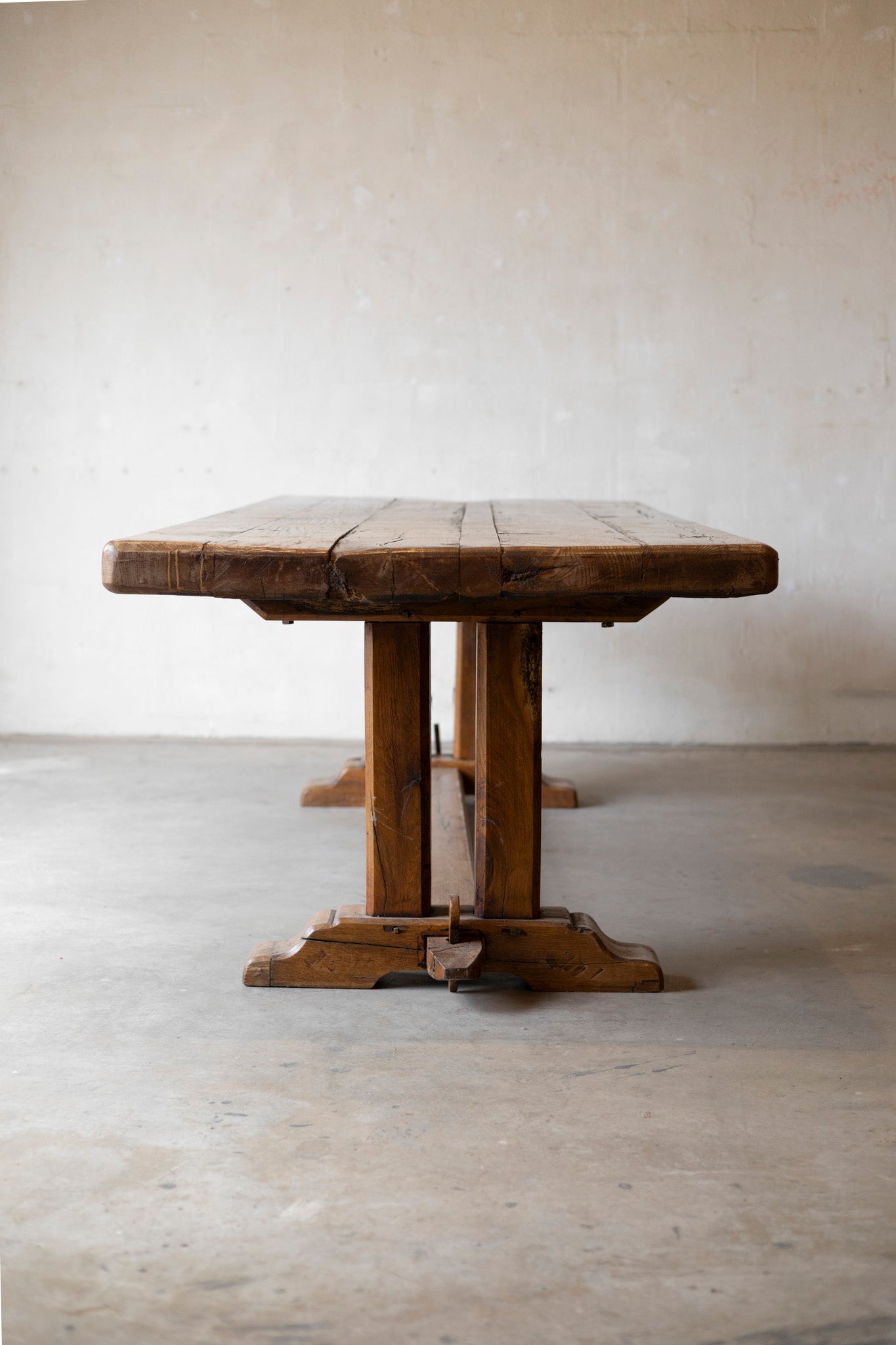 Wooden table with a rustic design on a plain floor and wall background