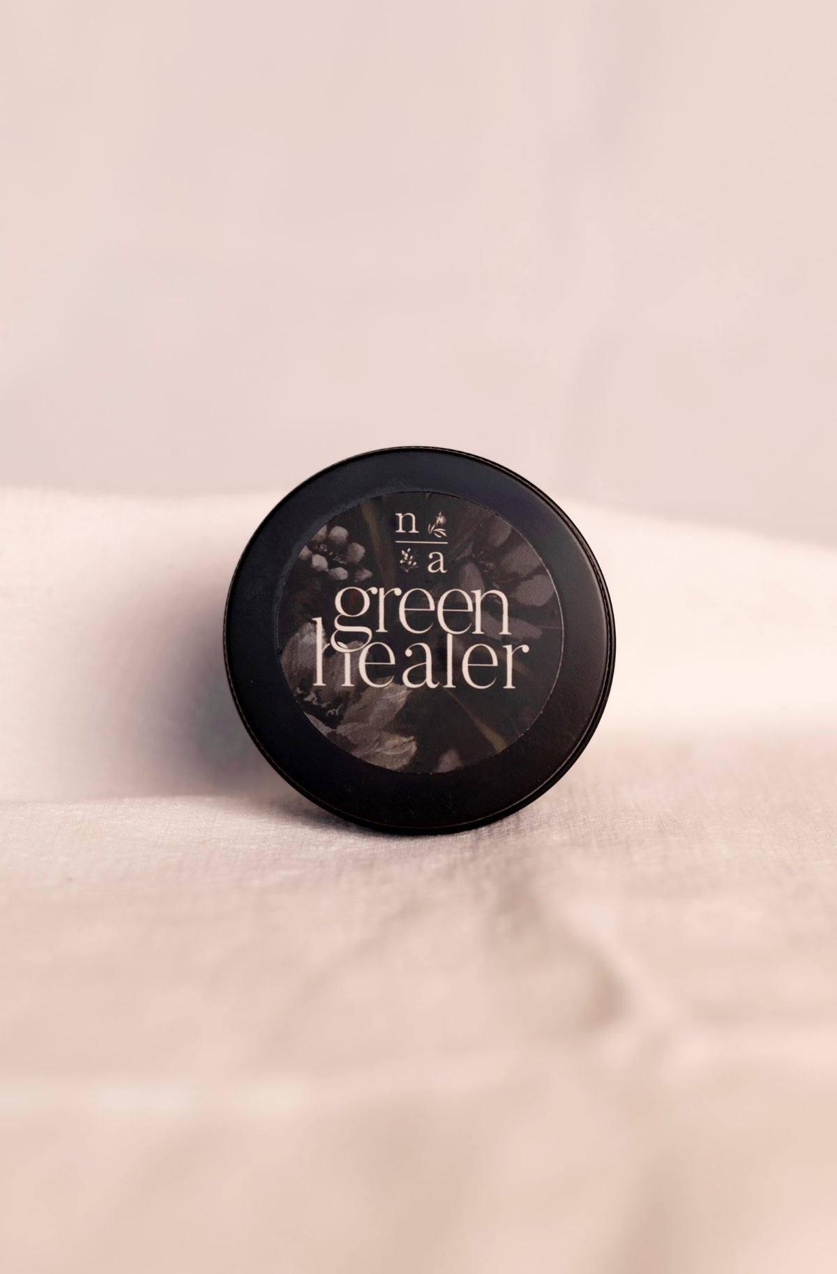 All natural ashe juniper moisturizing balm labeled 'green healer' on a soft white background.