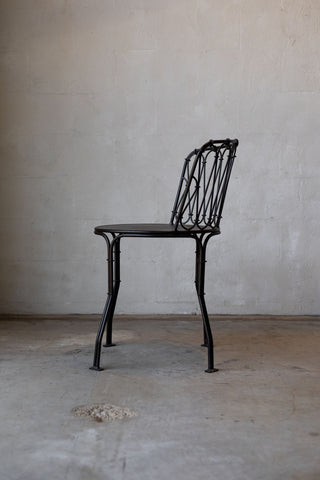 Side profile of iron French bistro style dining chair. 