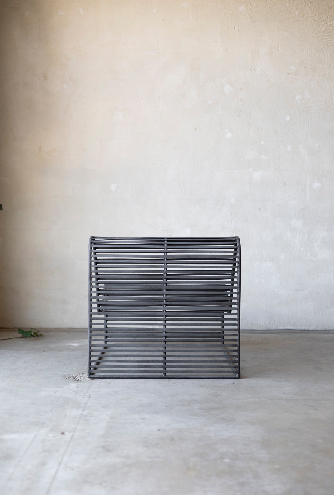 The Wave Chair on a concrete floor with a light gray wall background