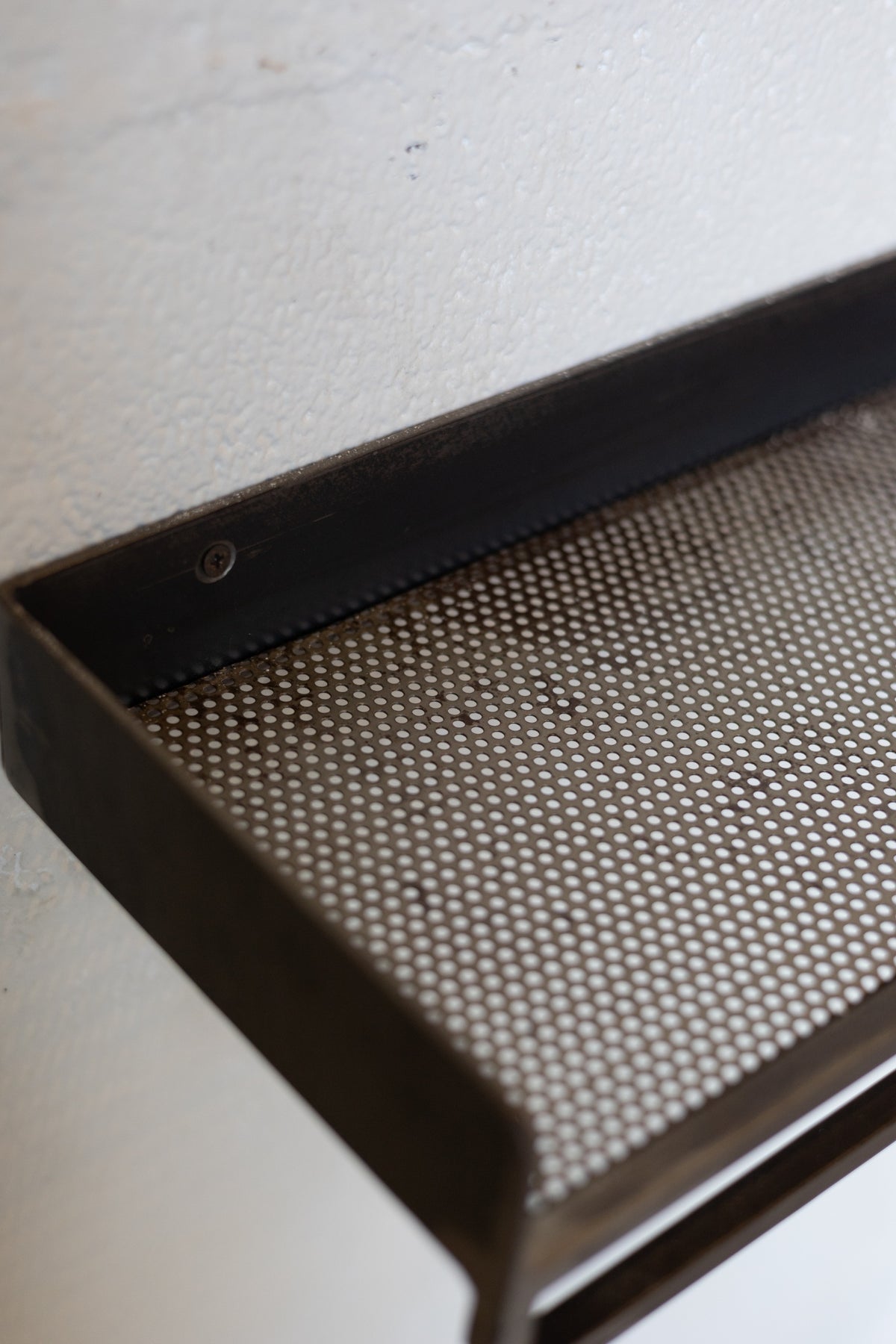Metal shelf with mesh design on a white background.