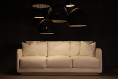 a white couch sitting in front of a black wall