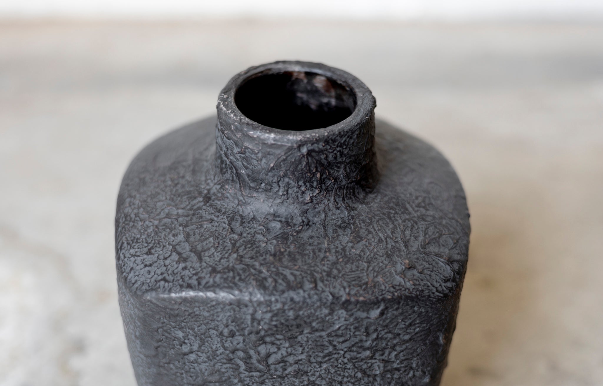 Textured black ceramic bottle on a light background