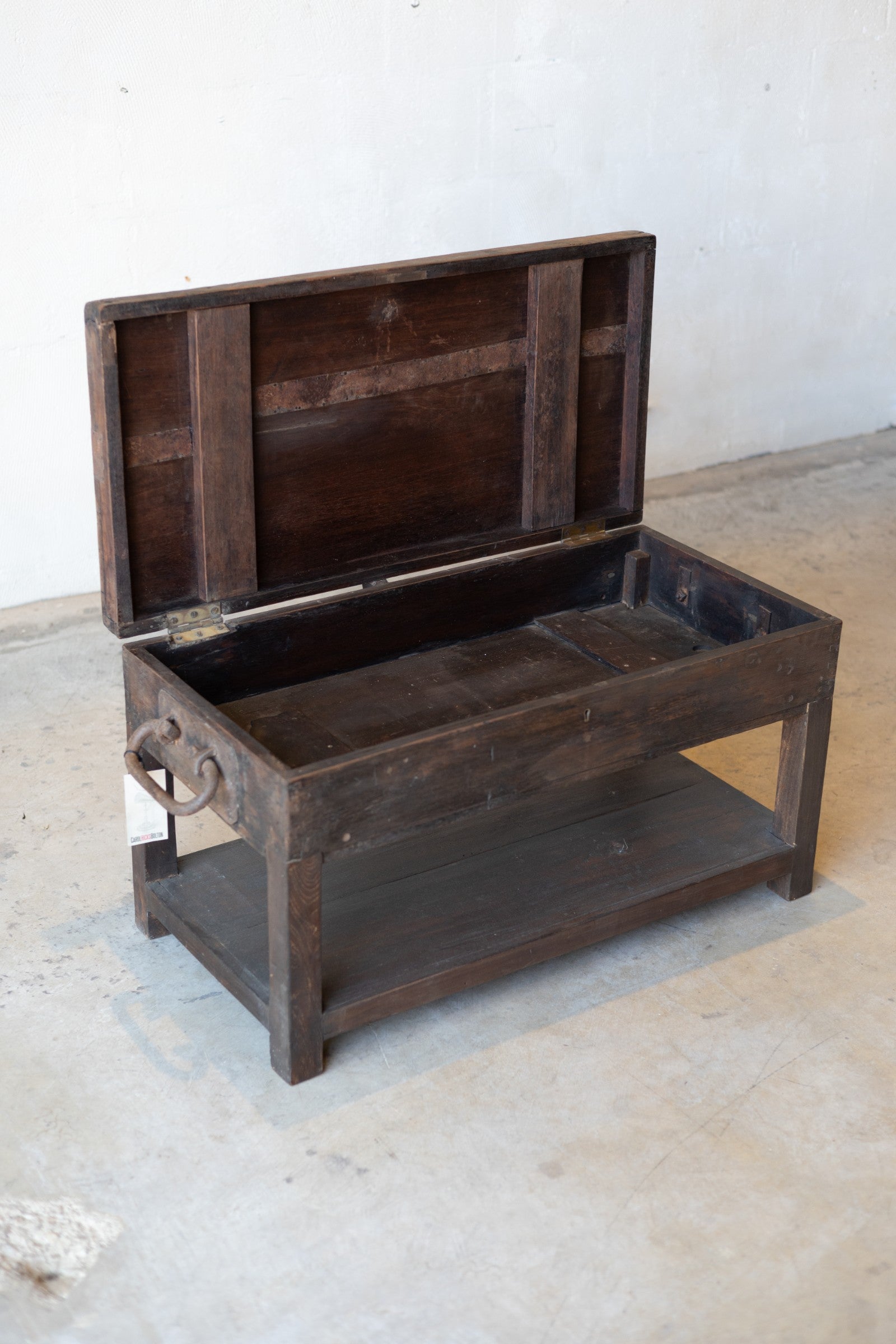 British colonial teak coffee table with iron handles and opening table-top for storage. 
