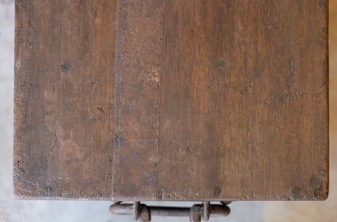 Close-up of a wooden surface of vintage teak coffee table with visible grain and texture from above.