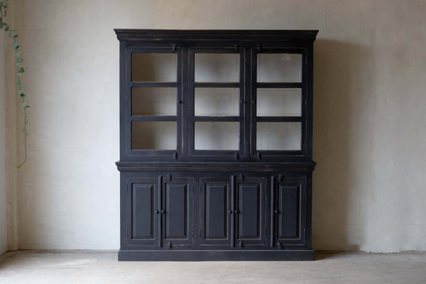 Black wooden hutch with three glass doors on top and five closed storage cabinets below, set against a neutral wall.