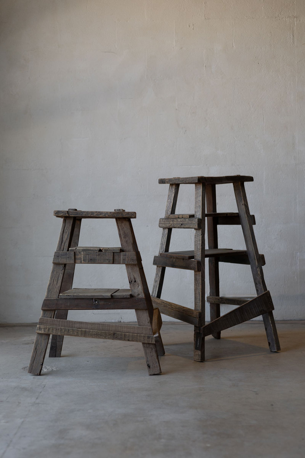 Pair of rustic wood painter stools of different heights. 
