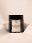 Jar of tallow body creme with a label on a beige background.