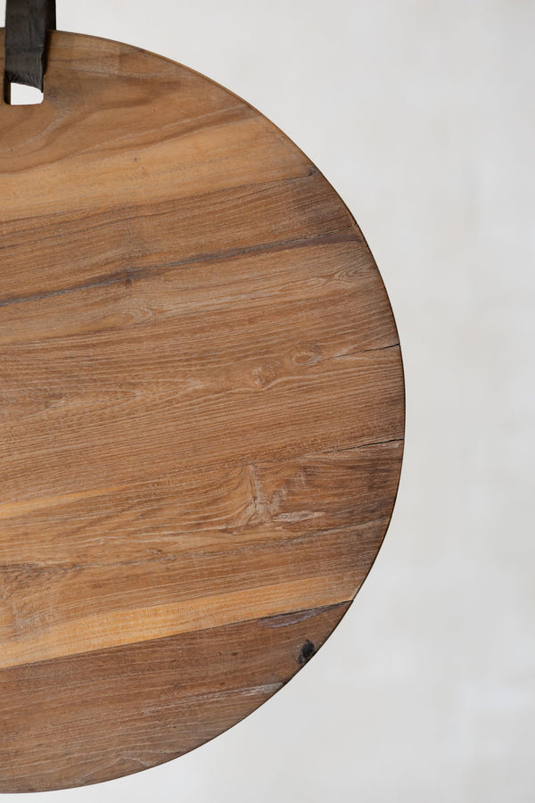 Side of round teak wood cheese board with leather strap. 