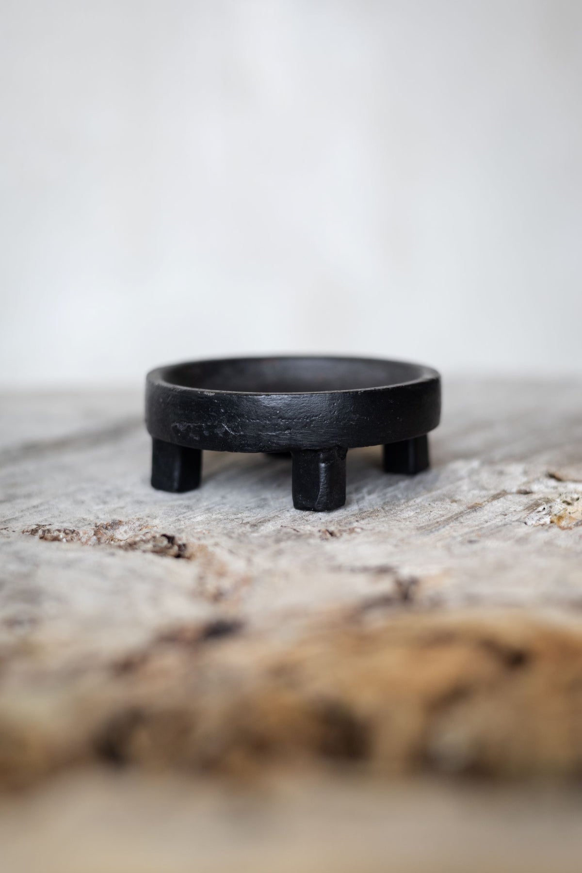 Side view of round black iron salt holder. Main image