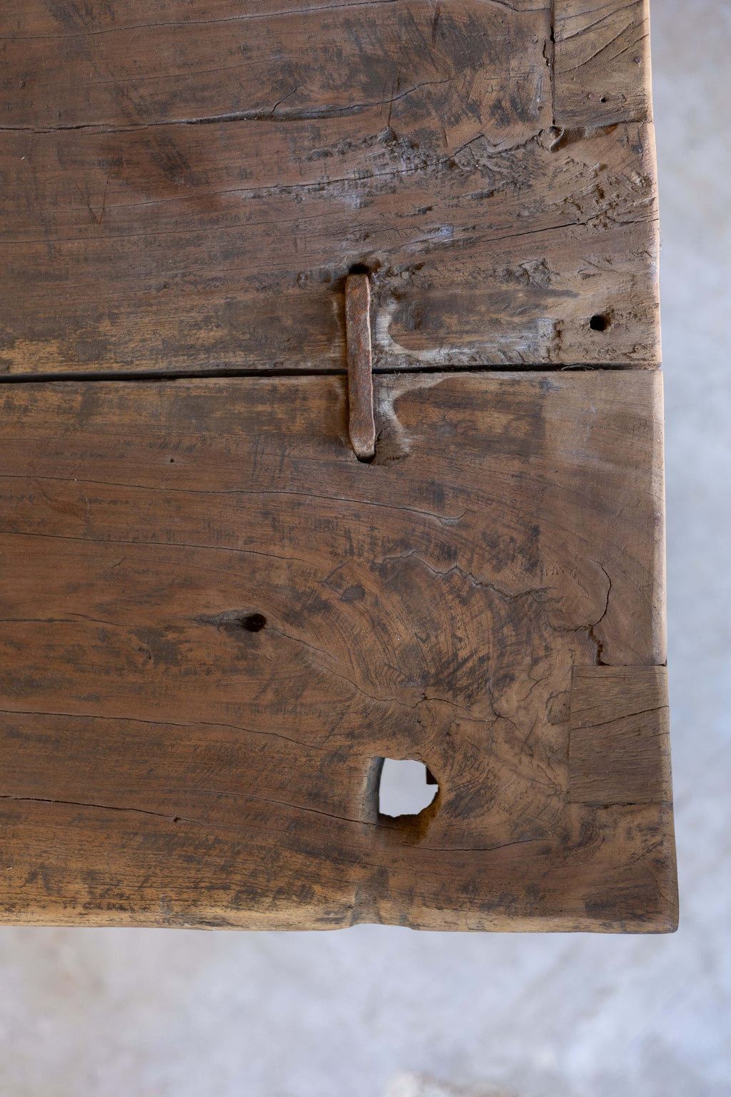 Close-up of wooden dining table's rustic top, showing wood's natural grain.