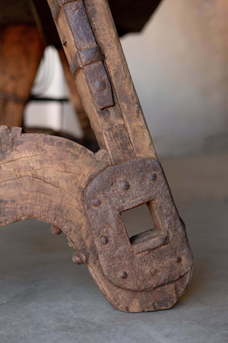 Close-up of sawhorse dining table's A-frame, showing leg's intricate, industrial reinforcements. 