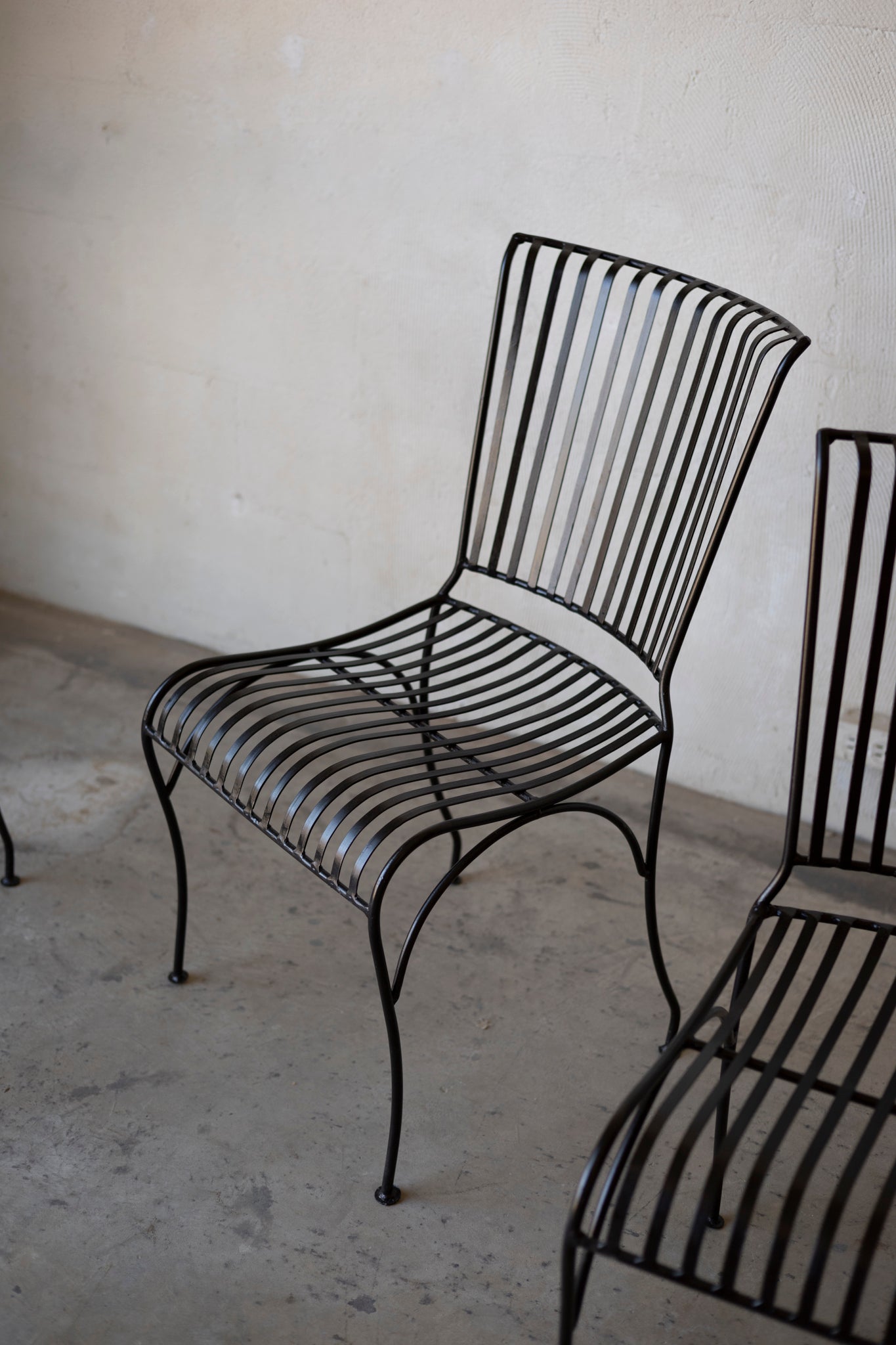 Black metal chair against a plain wall