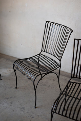 Black metal chair against a plain wall
