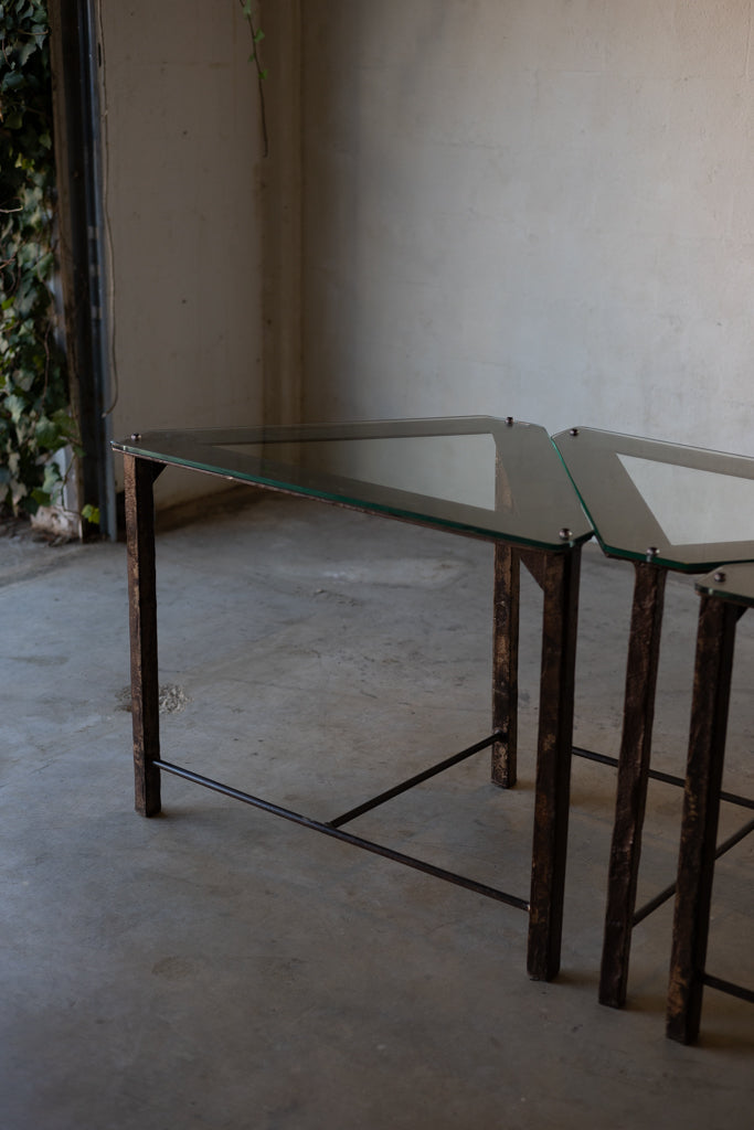 Triangular glass-top side tables with iron frames. 