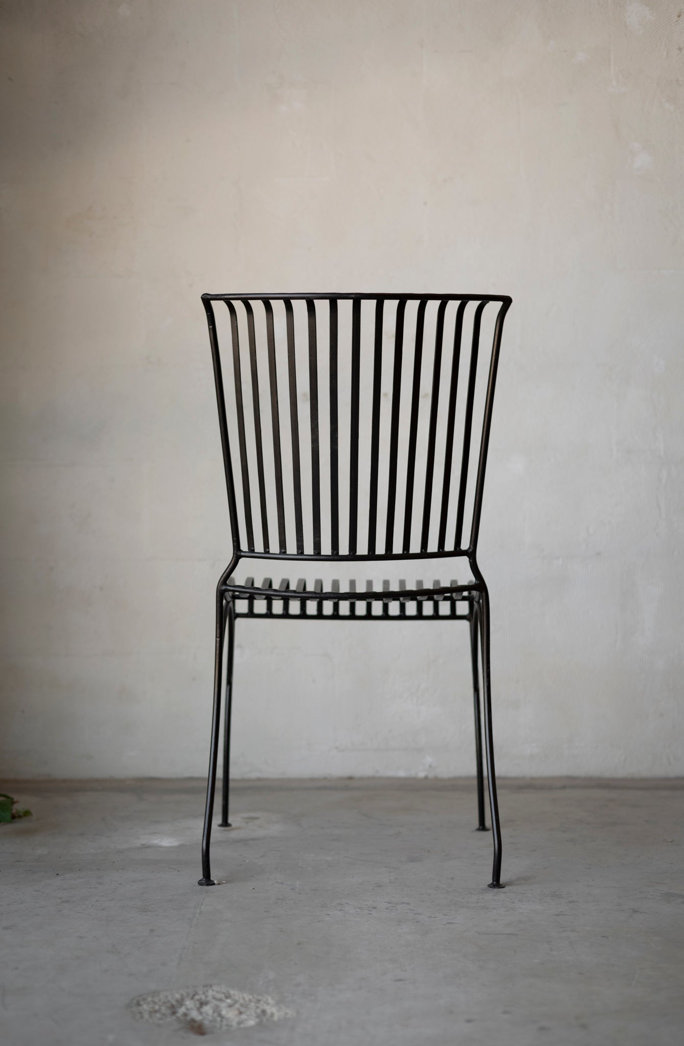 the back of a slatted iron dining chair