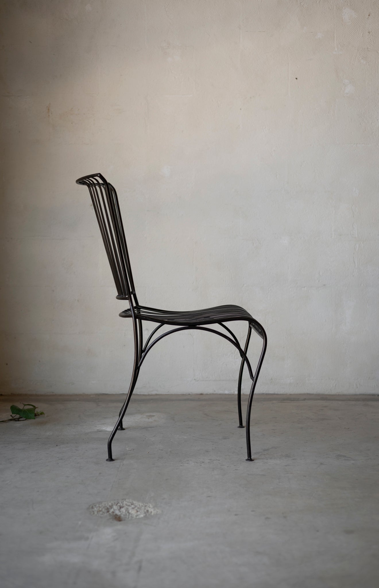 Black metal chair against a plain wall