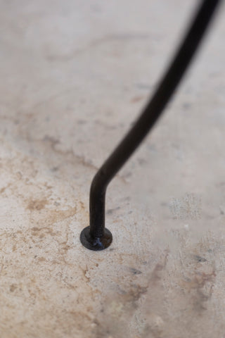 Black metal rod on a textured beige surface