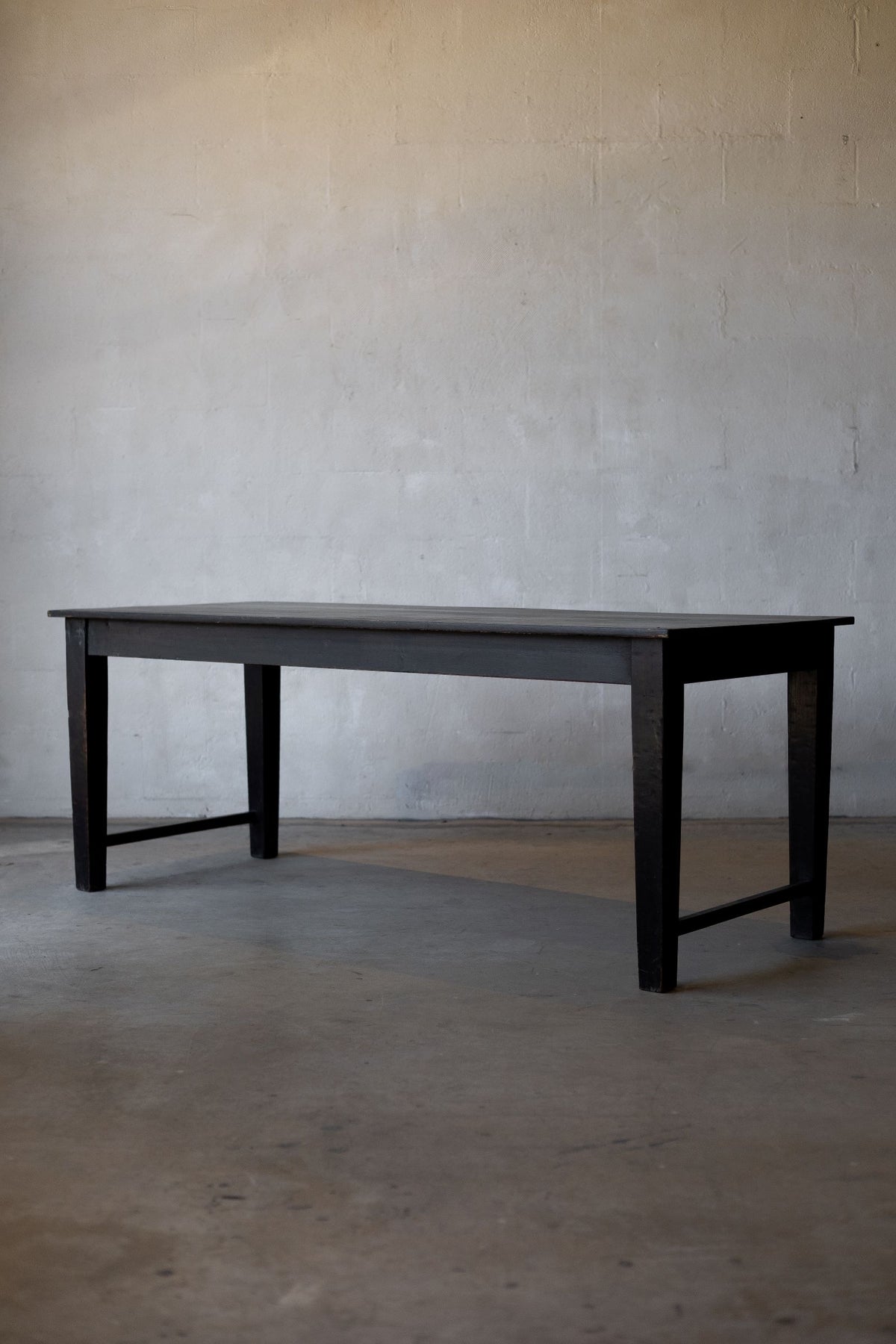 Black wooden table against a plain gray wall Main image