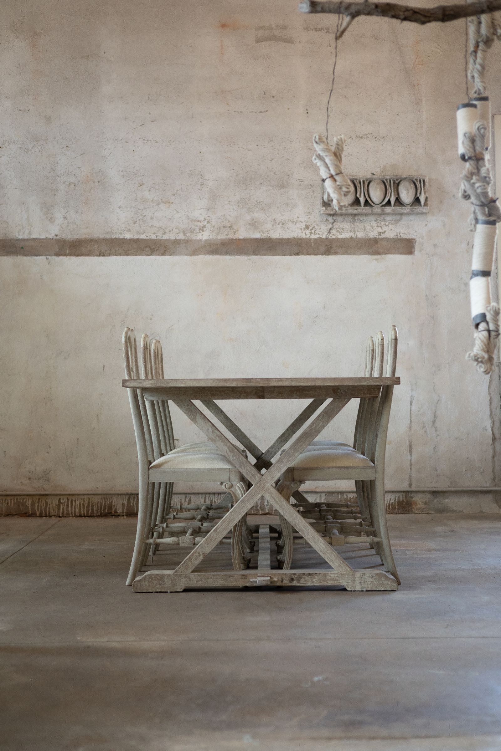Wooden dining table with chairs in a rustic room.