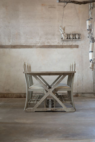 Wooden dining table with chairs in a rustic room.
