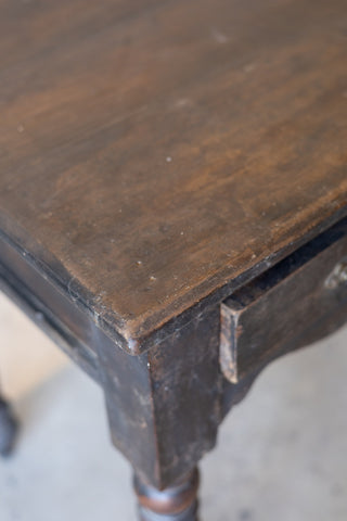 Close-up of the top of a vintage teak wood colonial desk with a worn surface
