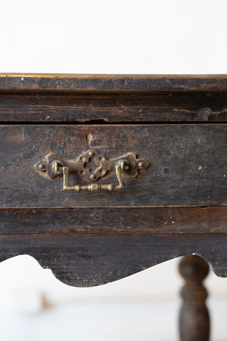 Close-up of a wooden drawer of vintage colonial teak wood desk with a decorative metal handle on a white background