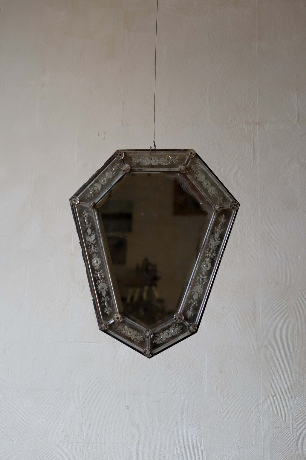 Venetian crystal mirror with shield shape and a beveled glass frame featuring intricate floral etchings.