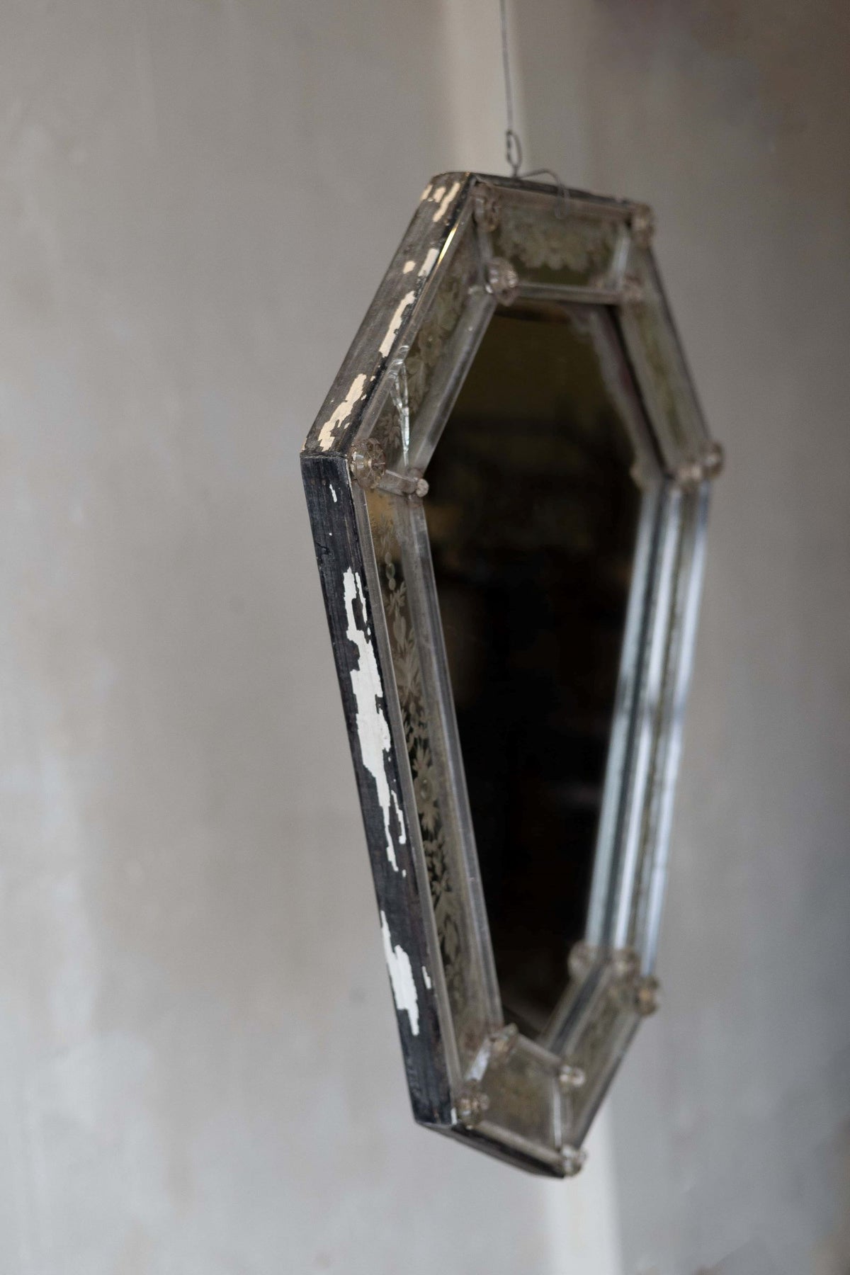 Side shot of Venetian crystal mirror with shield silhouette showing aged frame.