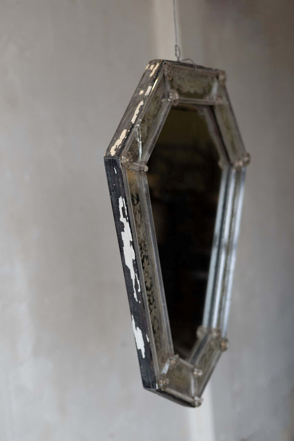 Side shot of Venetian crystal mirror with shield silhouette showing aged frame.