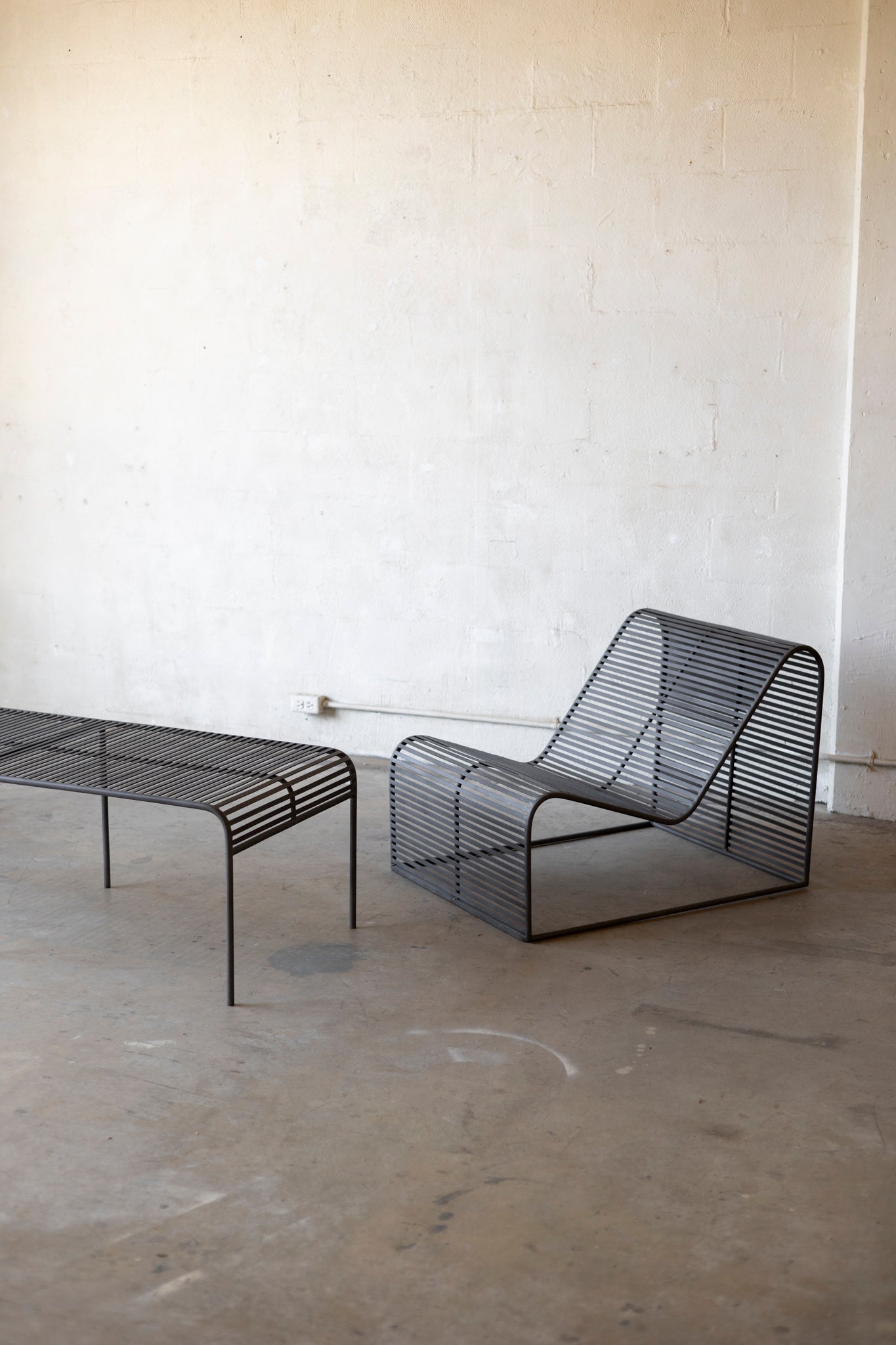 Wave Coffee Table paired with the Wave Chairs on a concrete surface