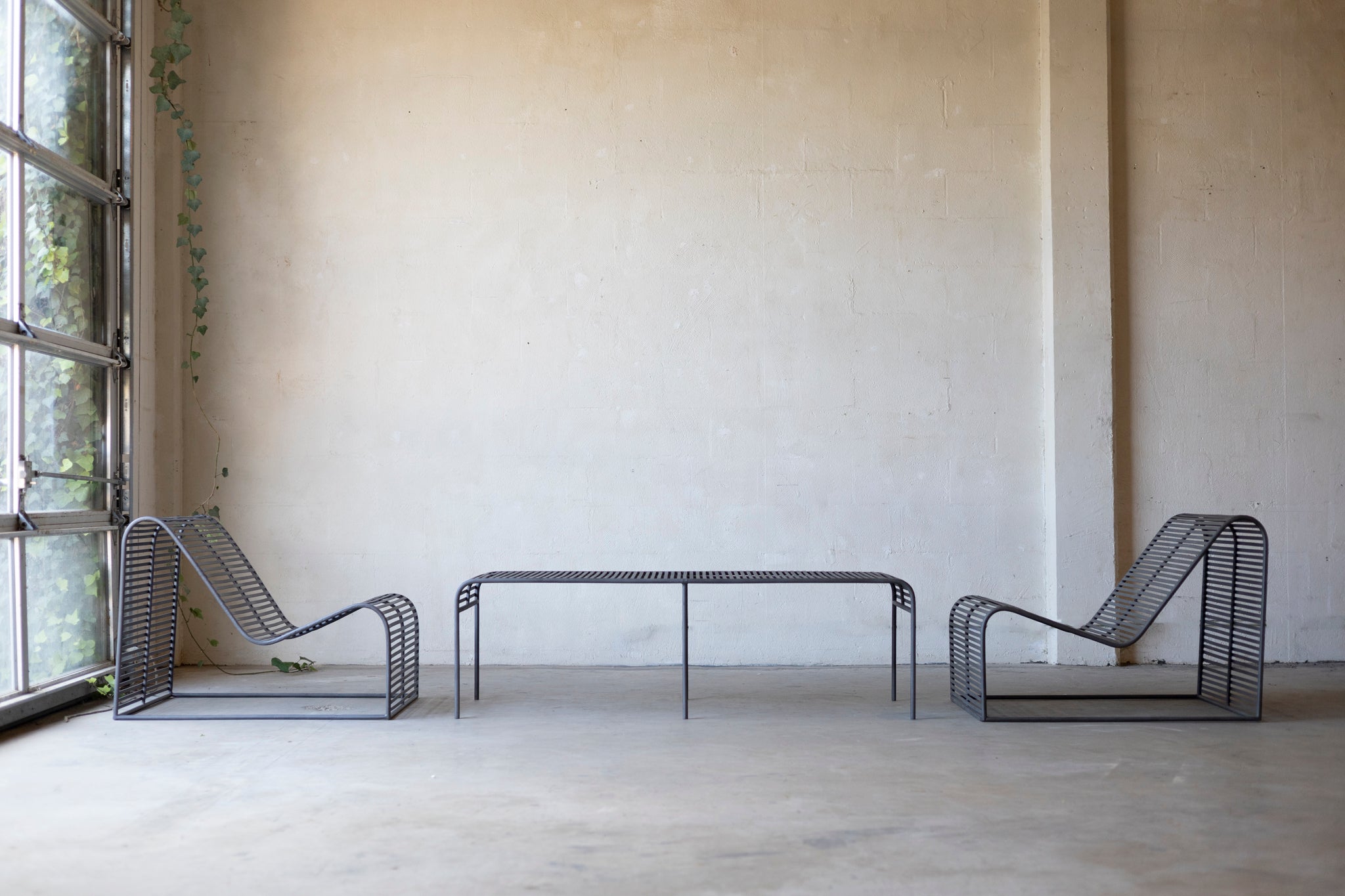 Wave Coffee Table paired with the Wave Chairs on a concrete surface