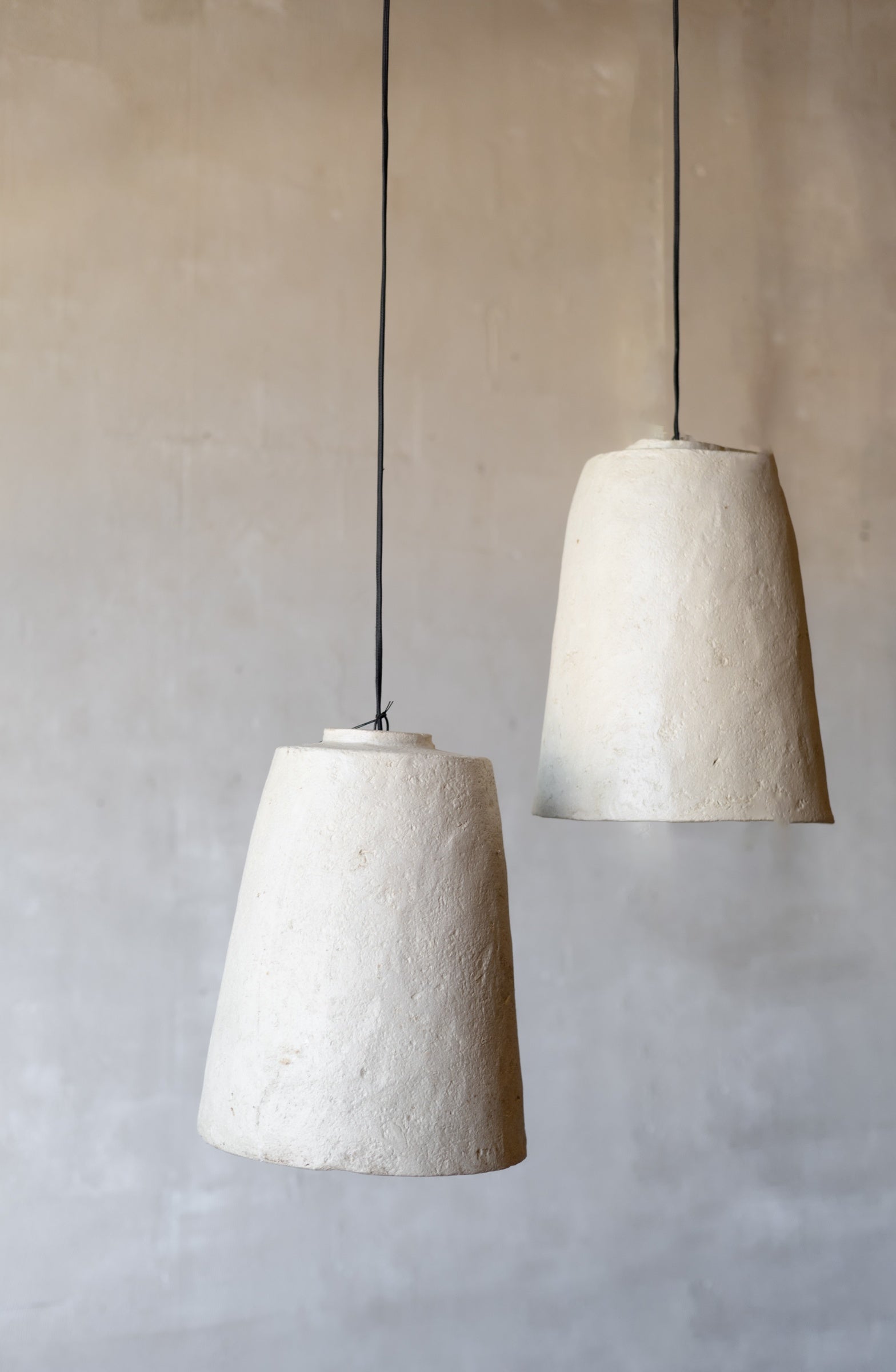 Two textured pendant lights hanging against a plain wall.