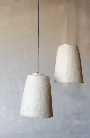Two textured pendant lights hanging against a plain wall.