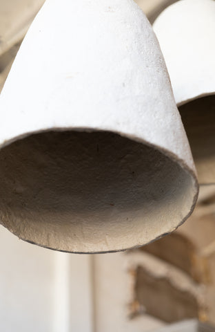 Close-up of a textured white pendant light from lower angle with a blurred background.