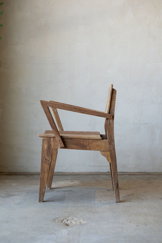 Side profile of antique art deco wood dining chairs with angled arm rests.