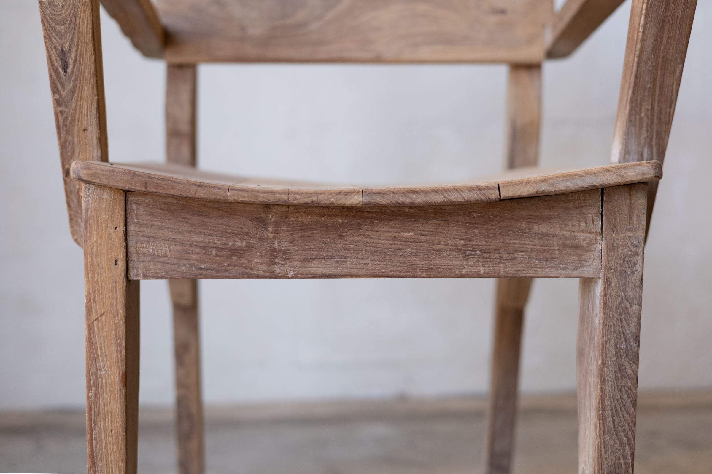 Close up of seat of antique art deco wood dining chairs showing curved seat. 