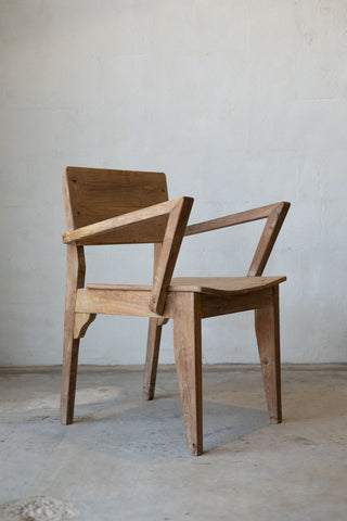 Angled photo of antique art deco wood dining chairs with angled arm rests.