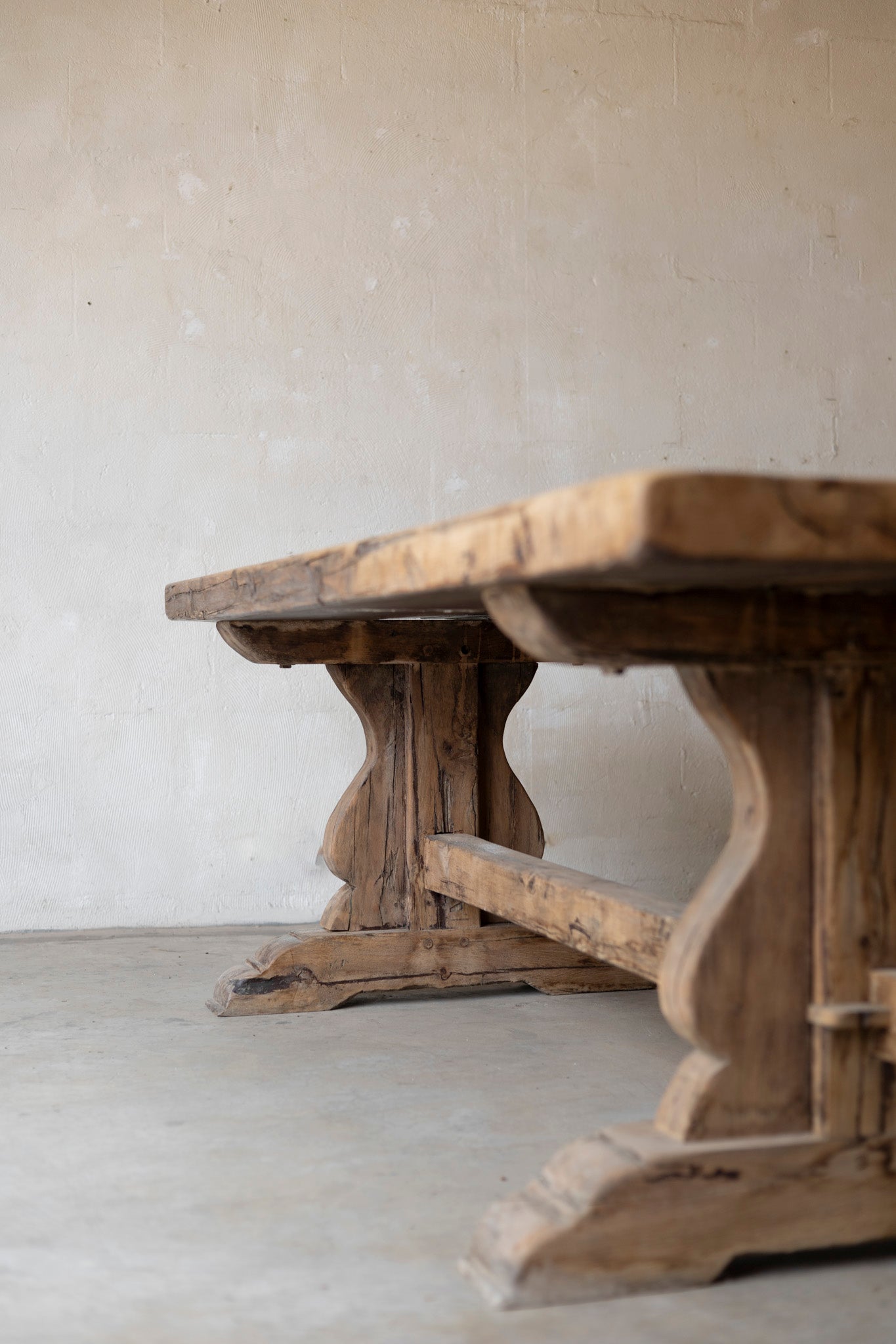 Wooden table with rustic design against a plain wall