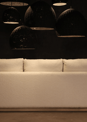 a white couch sitting in front of a black wall