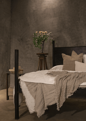 a bedroom with a bed and a vase of flowers