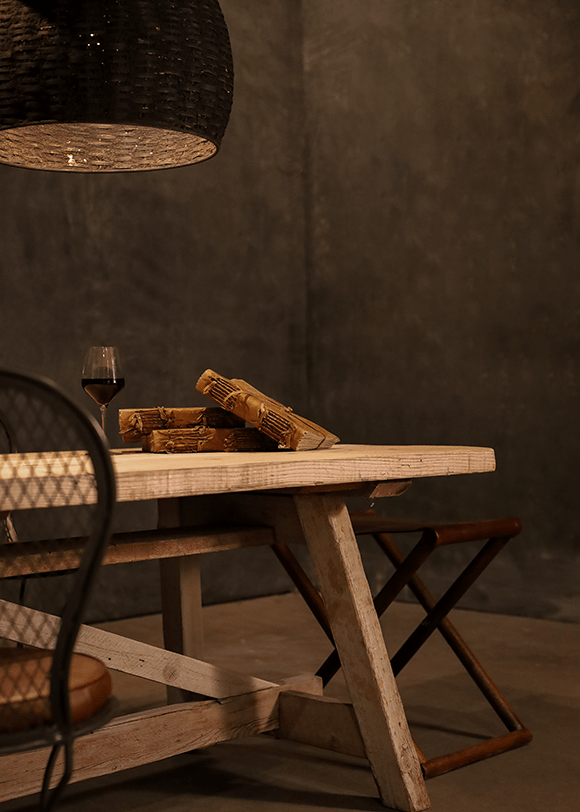 a table with a basket of bread and a glass of wine