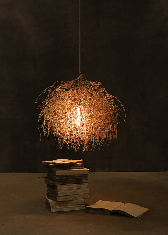 a light hanging over a pile of books